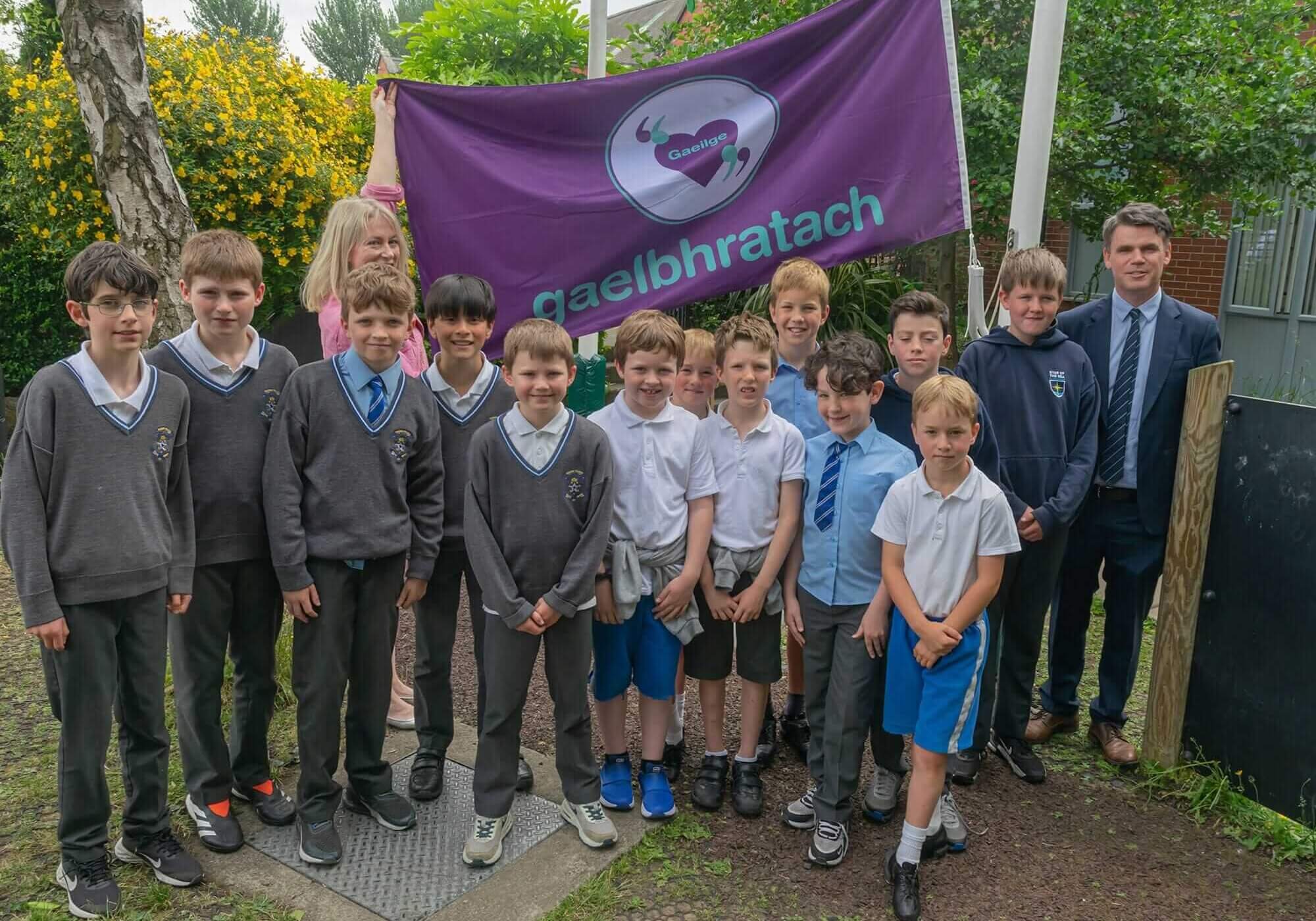 Boys-of-Star-of-the-Sea-with-the-flag-teacher-Faye-Mulhern-and-Principal-Niall-Walsh-min-min